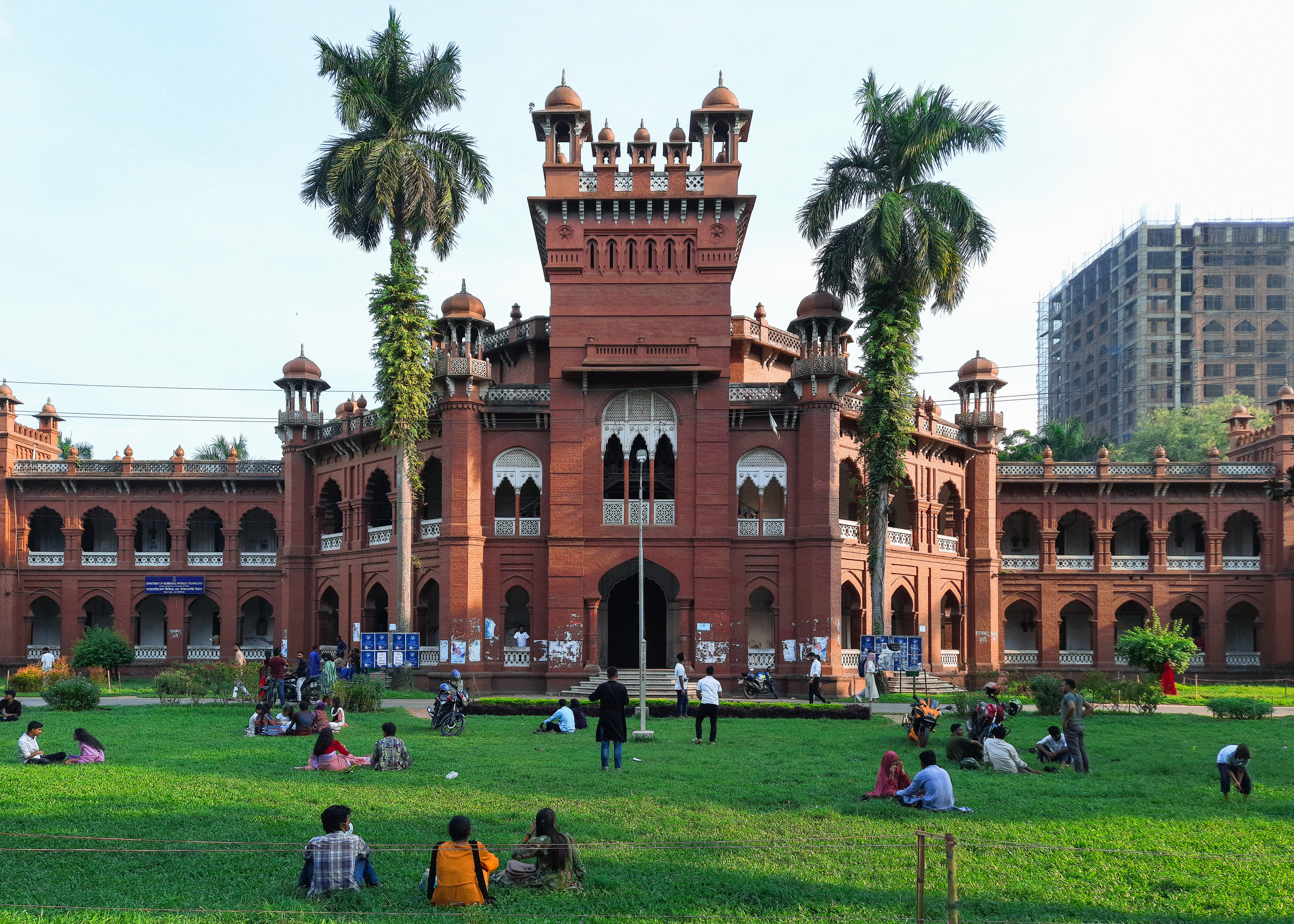 people-sitting-on-green-grass-field-near-brown-concrete-building