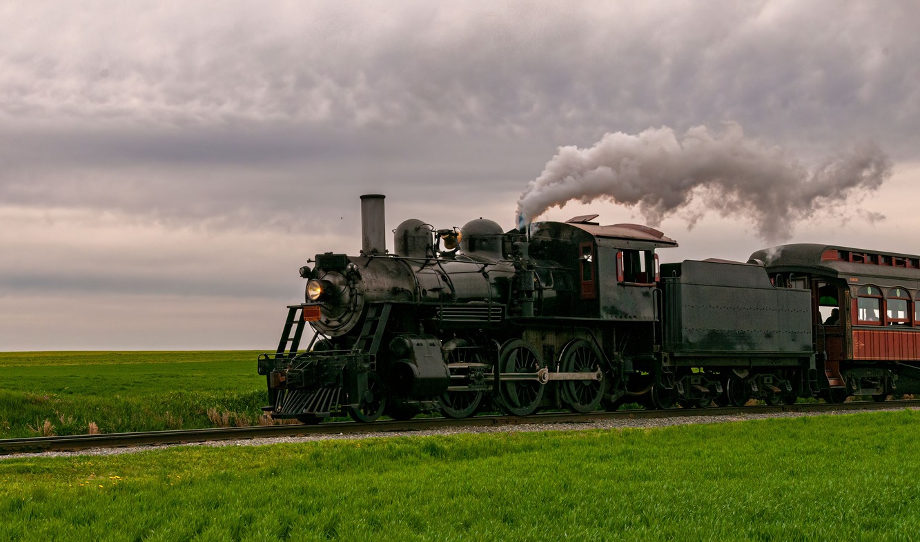 a steam engine travelling on a cloudy day