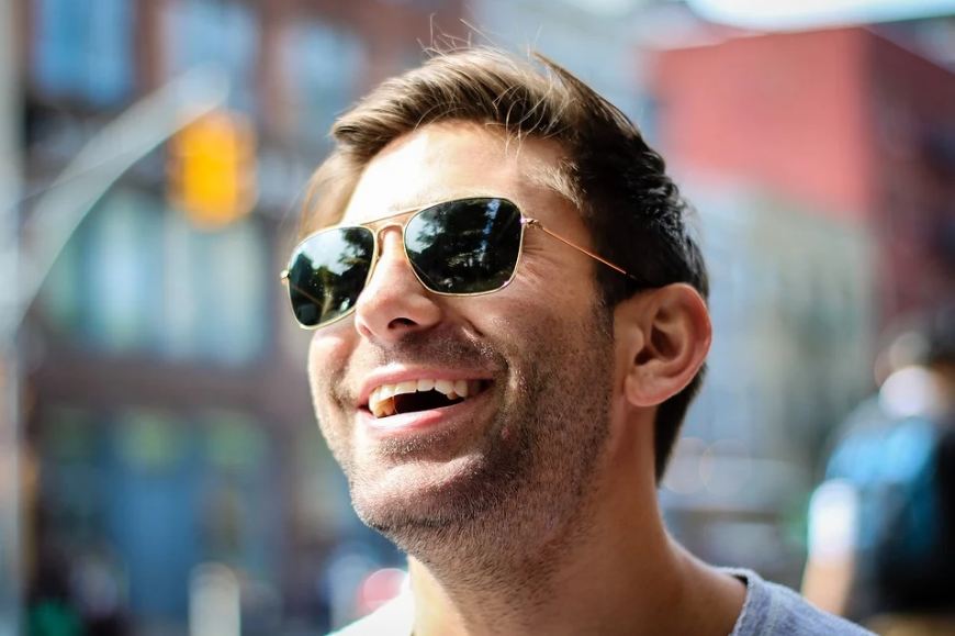 a man with sunglasses, smiling happily