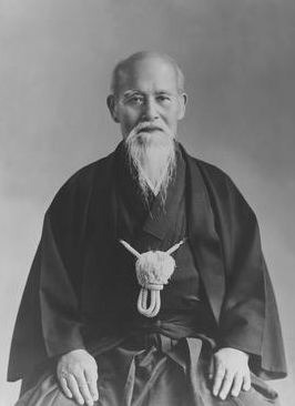 Portrait of an elderly Morihei Ueshiba in a traditional portrait.