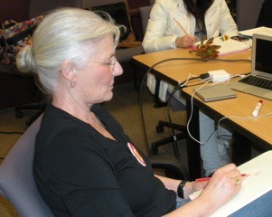 Photo of Kris Holmes sketching during a class she is teaching at RIT