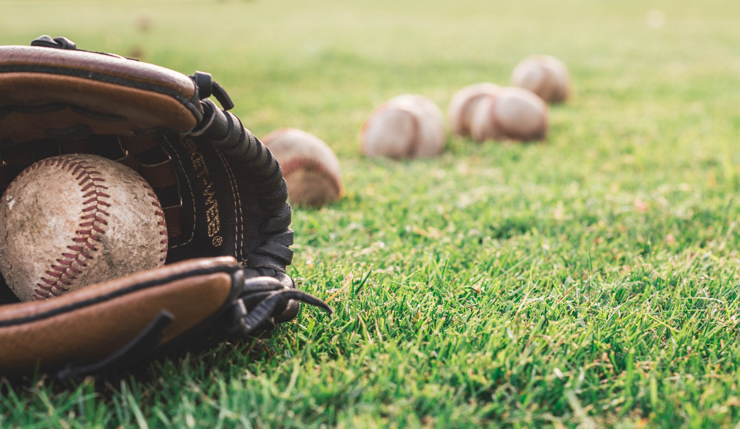 white-baseball-ball-on-brown-leather-baseball-mitt