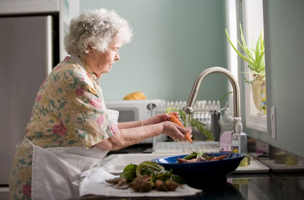 Elderly woman cleaning vegetables