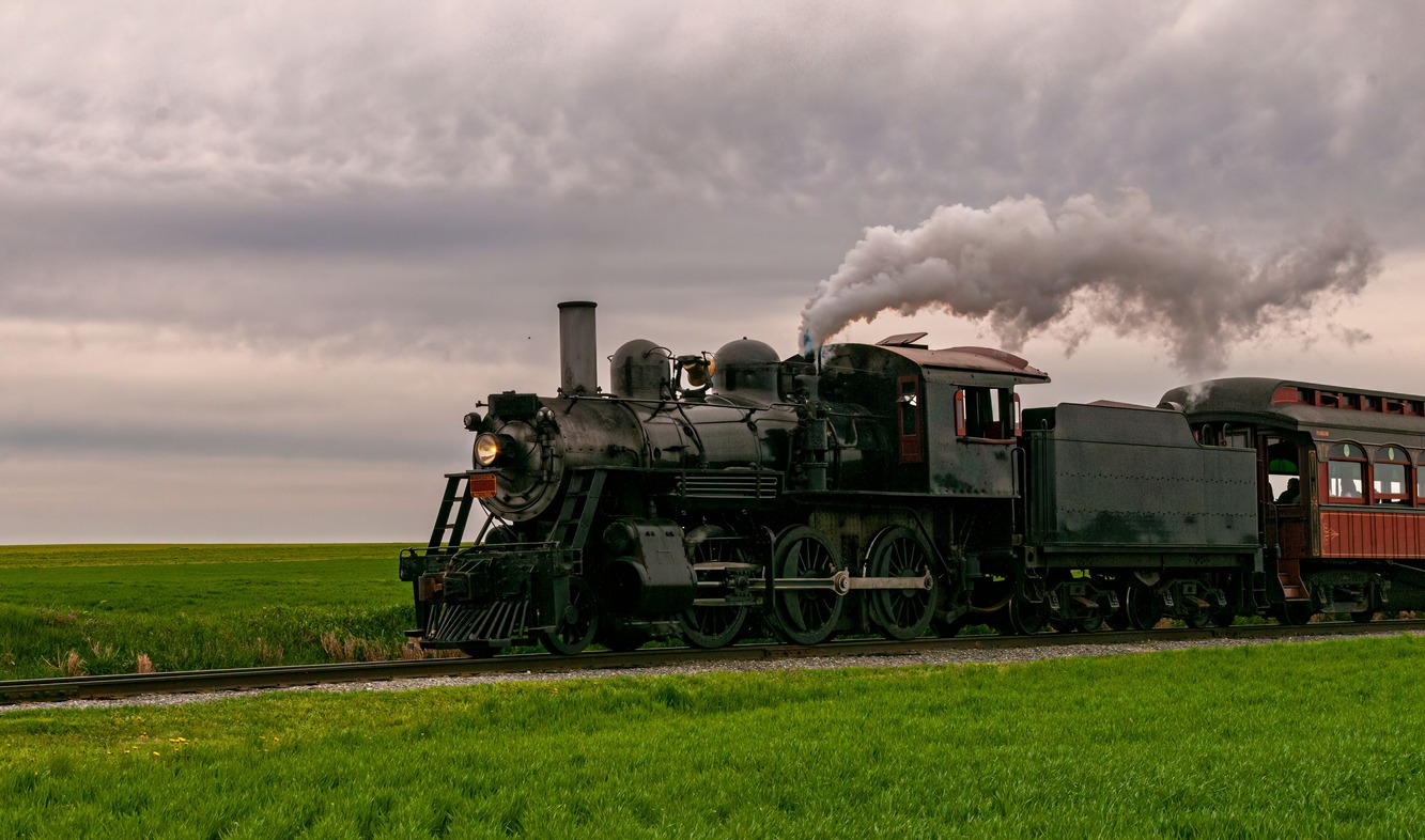 A steam engine travelling on a cloudy day