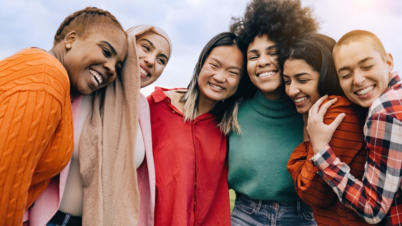 Group of multiracial women happily huddled together